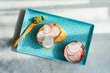 Toasted bread with pesto and radish slices
