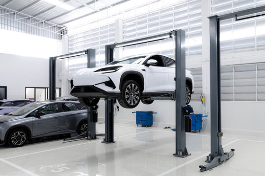 car at a service station on an electric lift , Bottom view of Electric car.