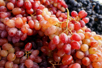 Close up of organic sweet red grapes background.Pile of fresh grape in a local market.