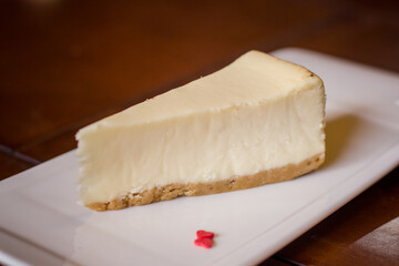 Cheesecake on white plate on wooden table. Selective focus