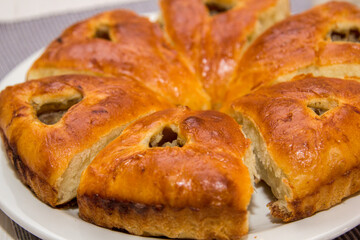 Freshly baked buns with raisins on a white plate