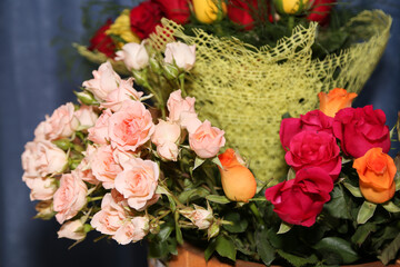 Beautiful bouquet of roses in basket on table close-up