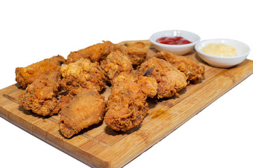  Fried chicken wings on a wooden board with ketchup and mayonnaise