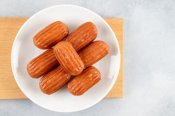 Traditional Turkish dessert tulumba on a plate. Tulumba dessert, fried in oil and soaked in syrup
