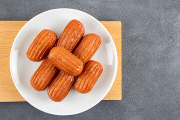 Traditional Turkish dessert tulumba on a plate. Tulumba dessert, fried in oil and soaked in syrup