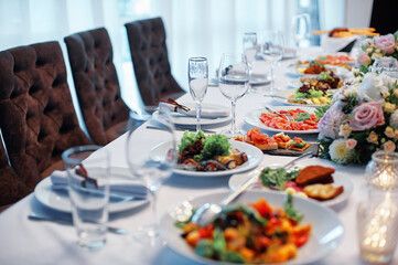Elegant Dining Table Setup with Assorted Dishes and Floral Arrangements..