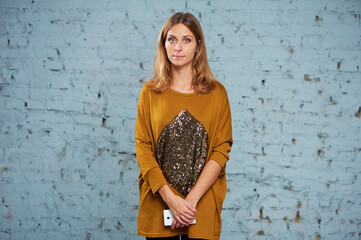 Casual Young Woman in a Stylish Outfit by a Textured Stone Wall..