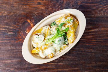 Delicious baked potatoes with creamy sauce and broccoli side dish
