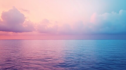 Obraz premium Colorful ocean horizon at sunset with soft clouds reflecting on calm waters