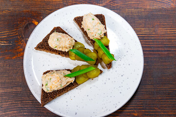 Delicious appetizers served on dark rye bread with pickles