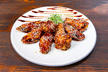 Deliciously glazed chicken wings served on a white plate