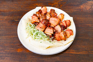 Delicious grilled meat served on a plate with shredded vegetables