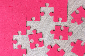 Red puzzle pieces scattered on a wooden surface.