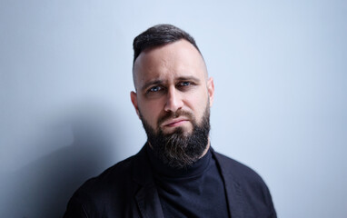 Studio portrait of young handsome man with beard.