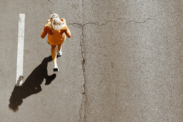 Woman running on asphalt road, top view