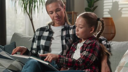 Caucasian family relaxing at home living room happy talking mother woman mom with adorable adopt custody girl kid child daughter looking at photo album conversation reading book photography watching - Powered by Adobe