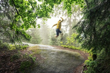 Obraz premium Joyful jump in a lush green forest.