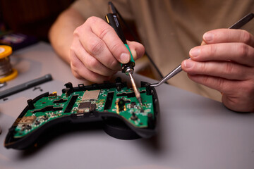 Hands Carefully Repairing a Circuit Board with a Soldering Tool for Electronics Projects