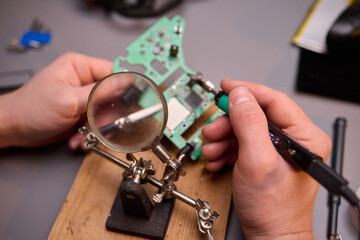 Hands Carefully Repairing a Circuit Board with a Soldering Tool for Electronics Projects