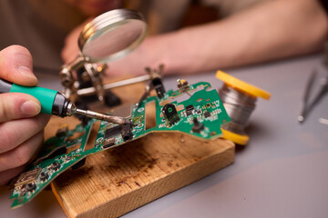 Hands Carefully Repairing a Circuit Board with a Soldering Tool for Electronics Projects