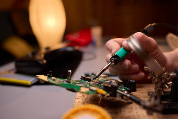 Hands Carefully Repairing a Circuit Board with a Soldering Tool for Electronics Projects