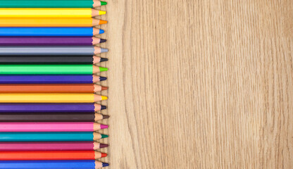 Fototapeta premium Background with colored pencils on a wooden background. Perfect for illustrating creativity, art, art projects, or education.