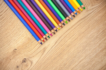 Obraz premium Background with colored pencils on a wooden background. Perfect for illustrating creativity, art, art projects, or education.