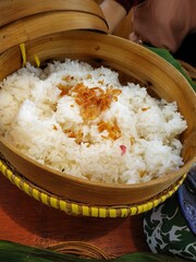 Close-up of Aromatic White Rice in a Natural Rattan Basket, Garnished with Golden Fried Shallots, Displaying Authentic Rural Cuisine in Indonesia