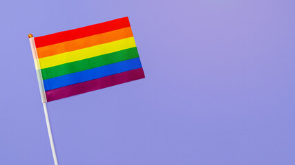 LGBT flag on purple background. Tolerance festival concept. Flat lay, top view. Free space for text.
