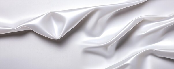 Obraz premium A smooth, white fabric drapes elegantly, showcasing soft folds and a lustrous sheen, perfect for various textile applications.