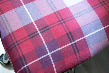 A close-up of a vibrant red and purple plaid fabric, showcasing intricate patterns and textures, perfect for design and fashion applications.