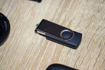 Close-up of a modern USB flash drive on a wooden surface, showcasing its sleek design and practicality for data storage and transfer.