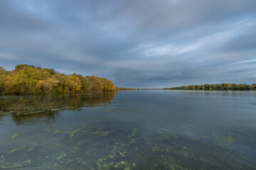 A lake with a cloudy sky in the background