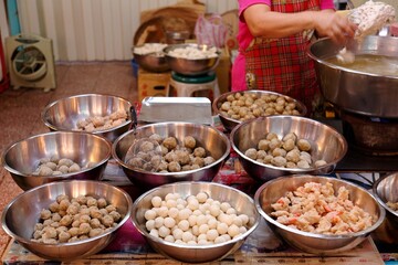 A stall vendor cooking meat balls and selling fish-balls, shrimp-balls,  stand in a popular marketplace in Xin-Fu Market, a marketplace where many traditional foods can be purchased, in Taipei, Taiwan