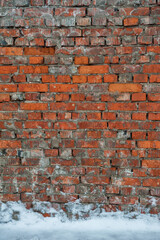 Weathered textures of rustic brick wall with snow