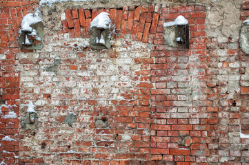 Weathered textures of rustic brick wall with snow