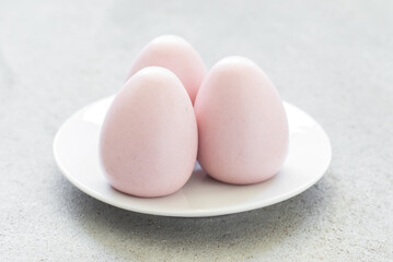 Easter dessert. Light berry cream mousse egg. On a plate. Close-up. Light background	