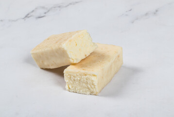 Cottage cheese coconut bar in white chocolate. White background