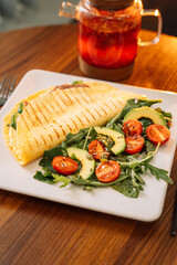 Tortilla with salad in a square white plate.