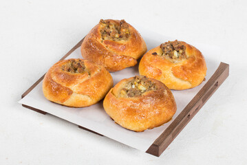 Small Open pie filled with fish, eggs and onions. On a wooden board. White background