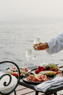 A luxurious oceanfront dining experience featuring a scenic view of the sea, elegant table setup, and gourmet cuisine. Perfect setting for a relaxing and sophisticated meal by the water in Greece
