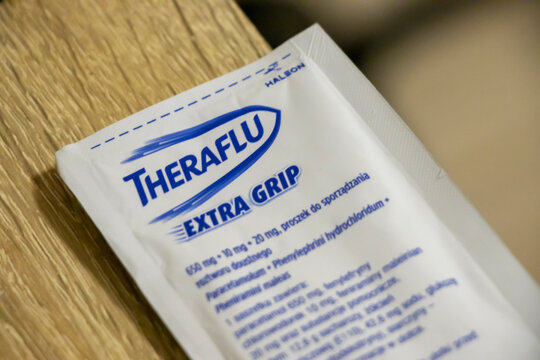 Warsaw, Poland - January 19, 2025: A close-up of a Theraflu package on a wooden surface, highlighting its medical purpose and design for cold relief.