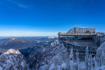 Stunning view of the Alps with the panorama platform on German side on top of Zugspitze, on a sunny winter day with blue sky and cloud, Garmisch-Partenkirchen, Bavaria, Germany