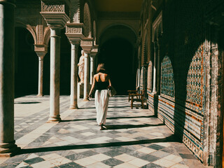 Young woman shoulders walking through an Andalusian porch