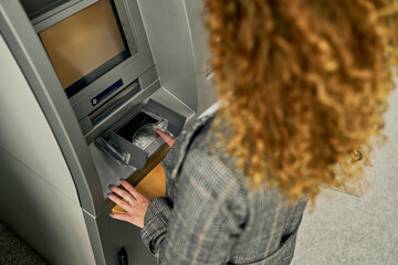 Capturing a moment of security, the young woman enters her PIN with a sense of assurance, ensuring...