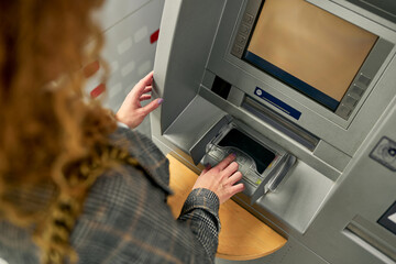 Capturing a moment of security, the young woman enters her PIN with a sense of assurance, ensuring a protected and confidential transaction at the ATM.