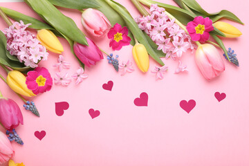 Beautiful colorful flowers and paper hearts on pink background, top view