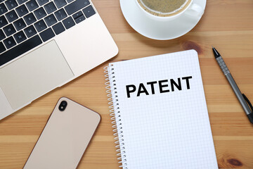 License. Word Patent in notebook, smartphone, pen and laptop on wooden table, flat lay