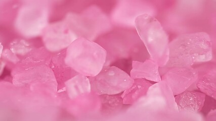 Falling crystals of pink sea salt in slow motion.