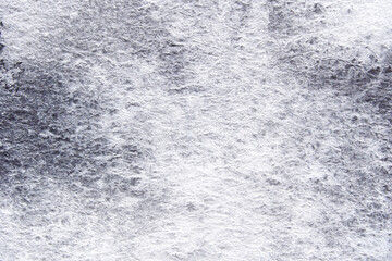 Abstract textured surface with subtle patterns and shades in monochrome palette.